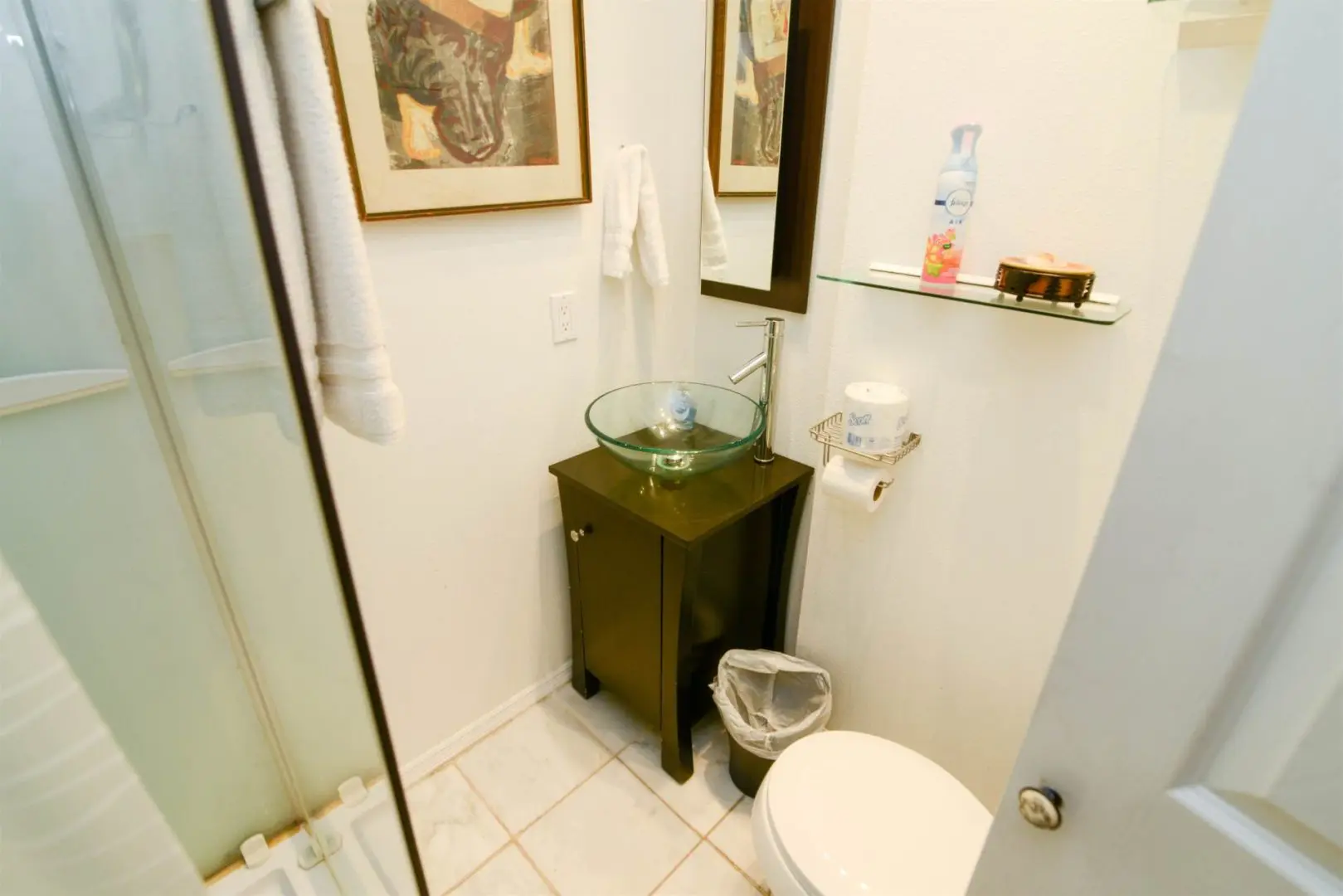 A bathroom with a toilet, sink and shower.