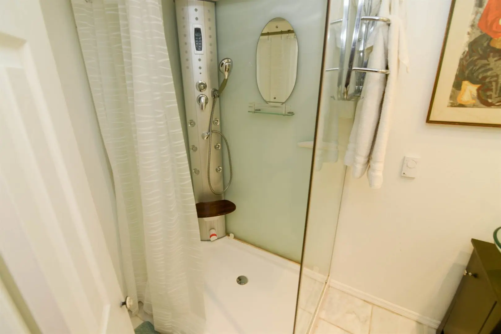 A bathroom with a shower stall, sink and mirror.