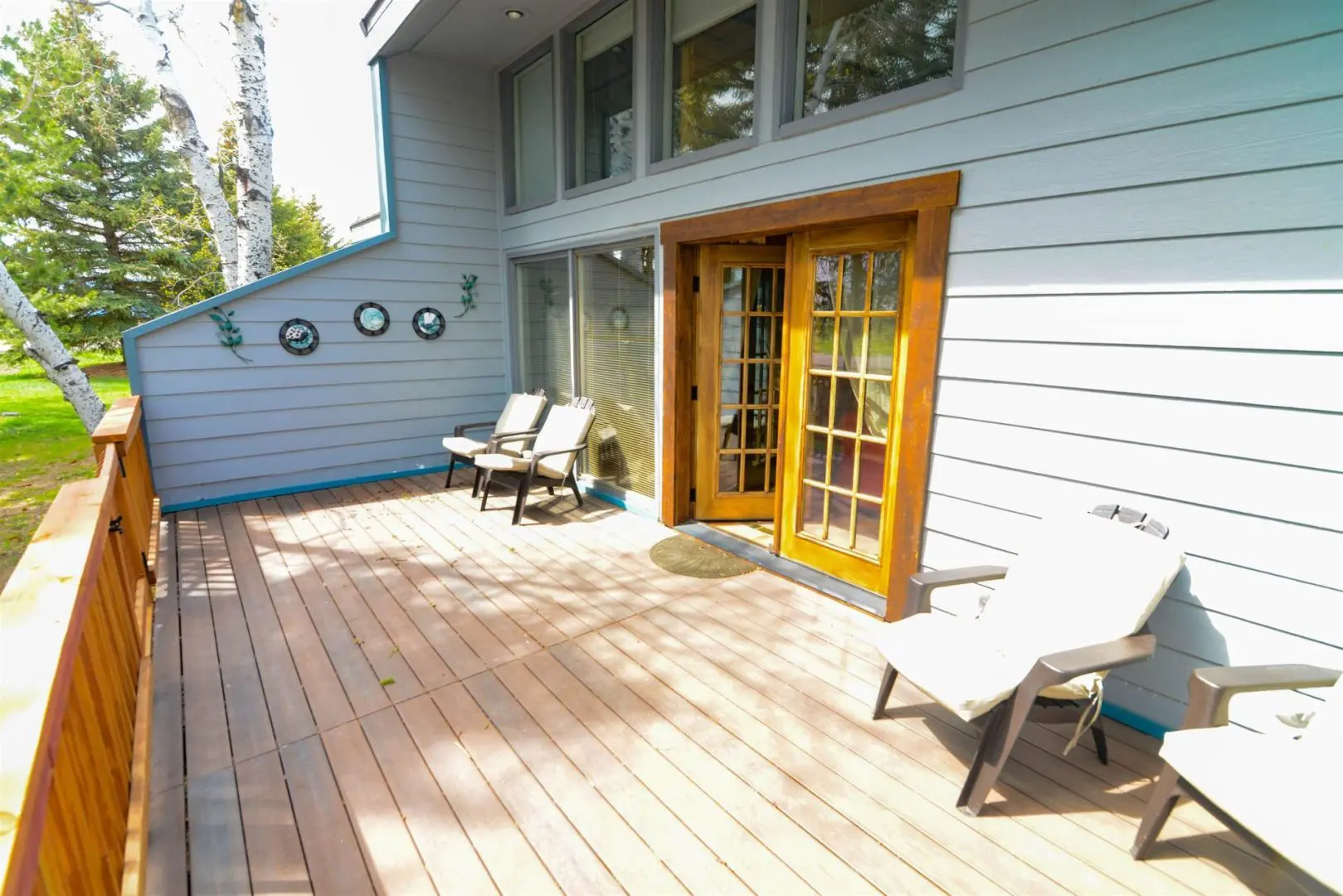 A deck with chairs and a wooden door.