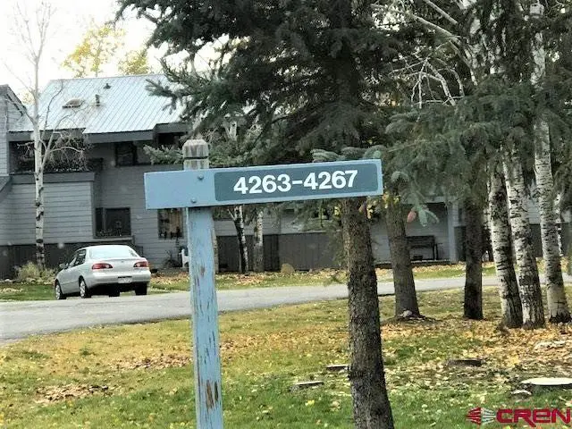 A street sign in front of an apartment building.