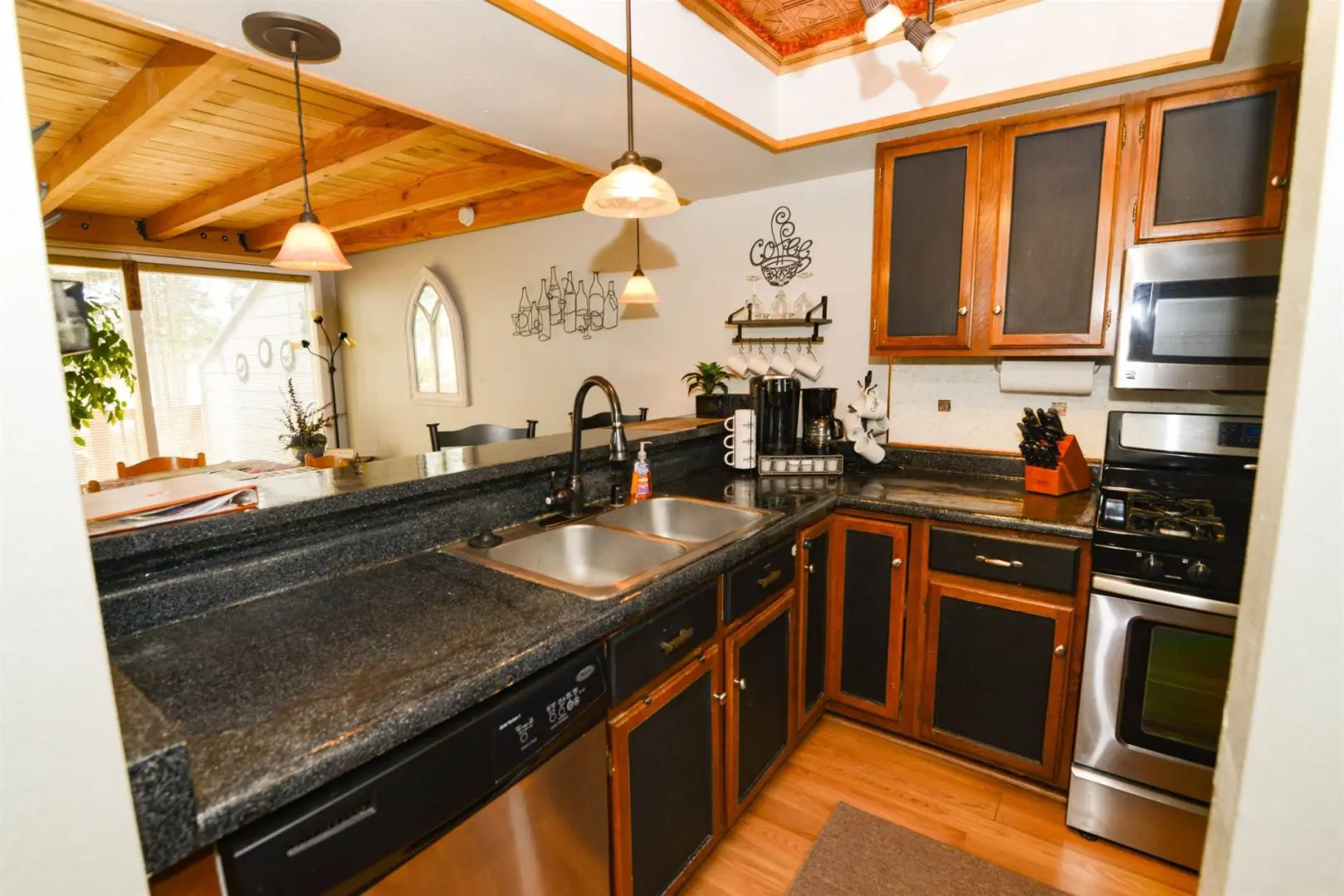 A kitchen with black cabinets and stainless steel appliances.