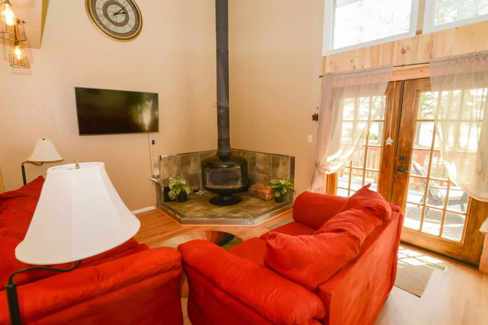 A living room with red couches and a fireplace.