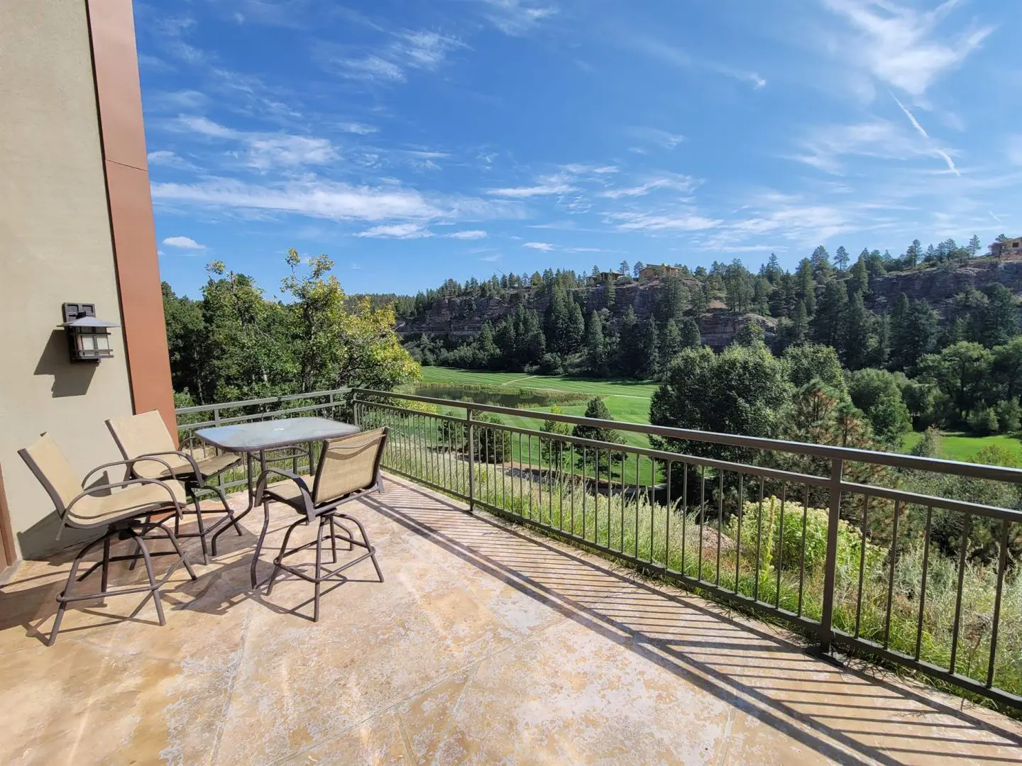 A balcony overlooking a golf course and mountains.