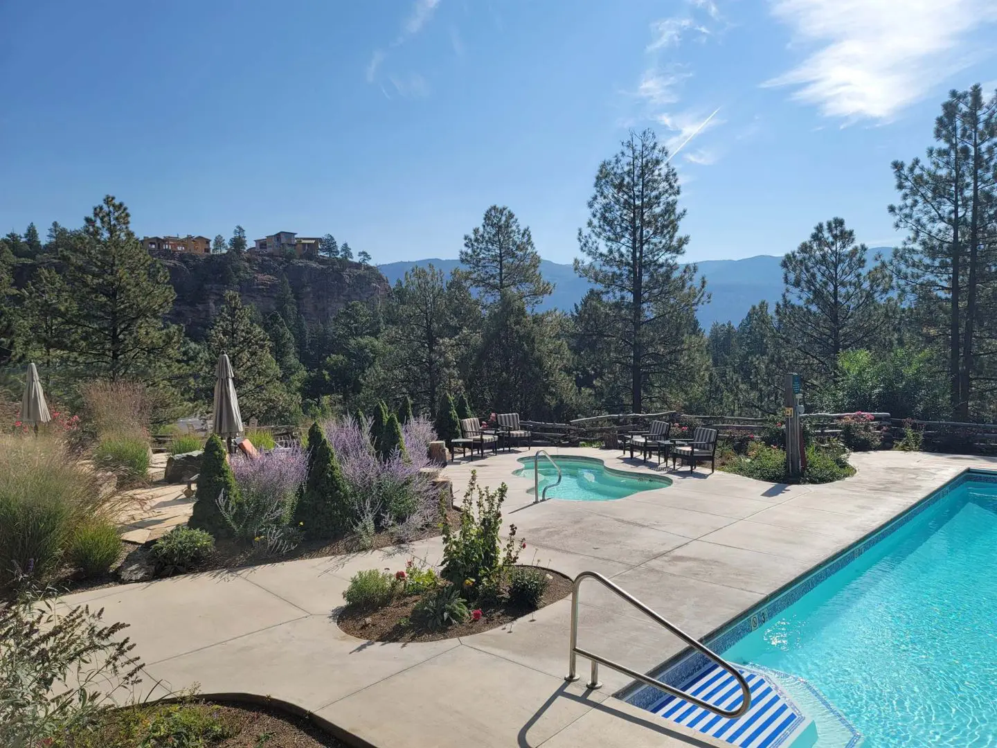 A swimming pool surrounded by trees and mountains.