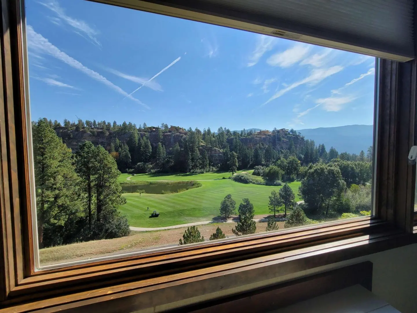 A view of a golf course from a window.