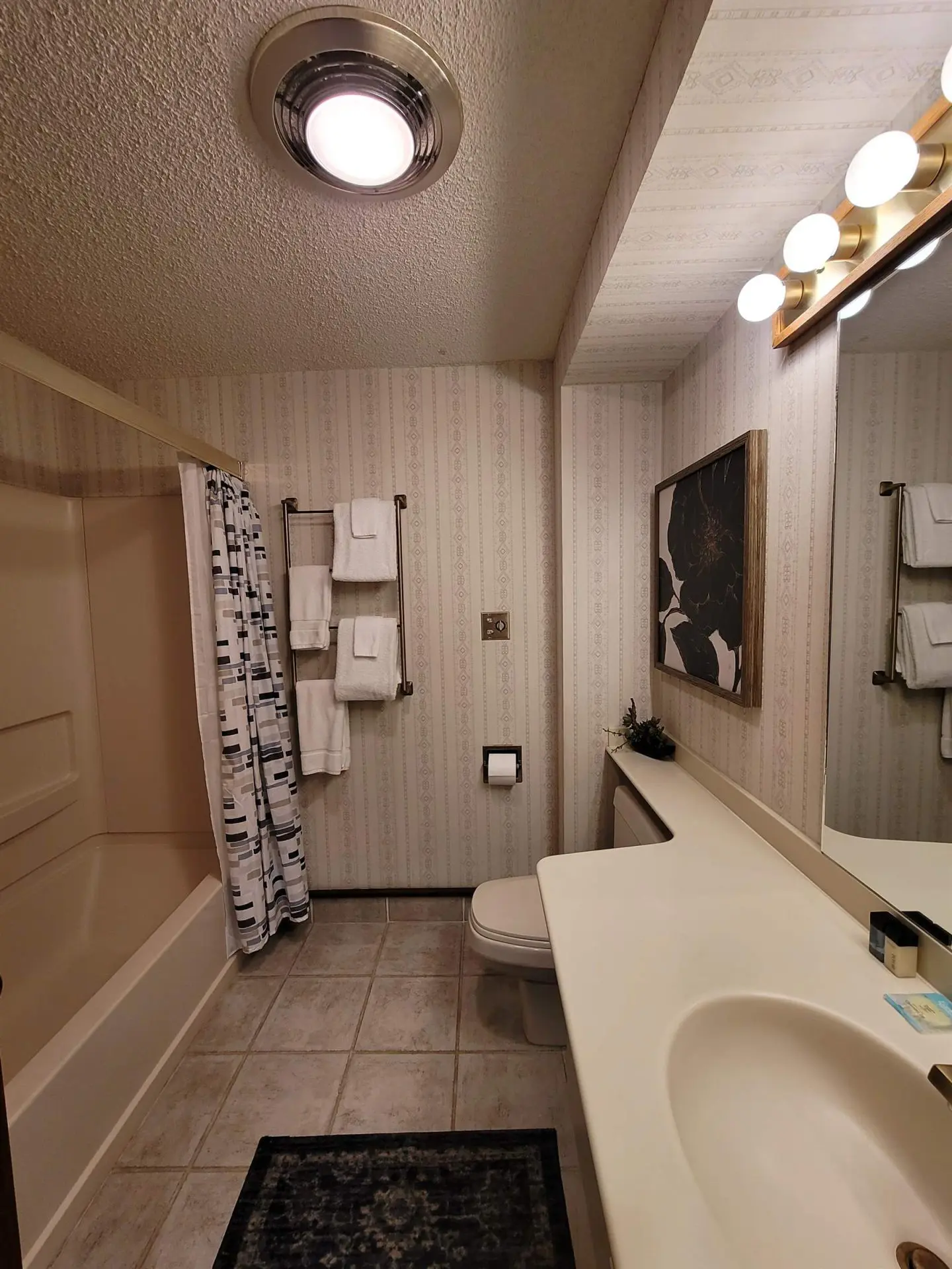 A bathroom with a sink, toilet and shower.