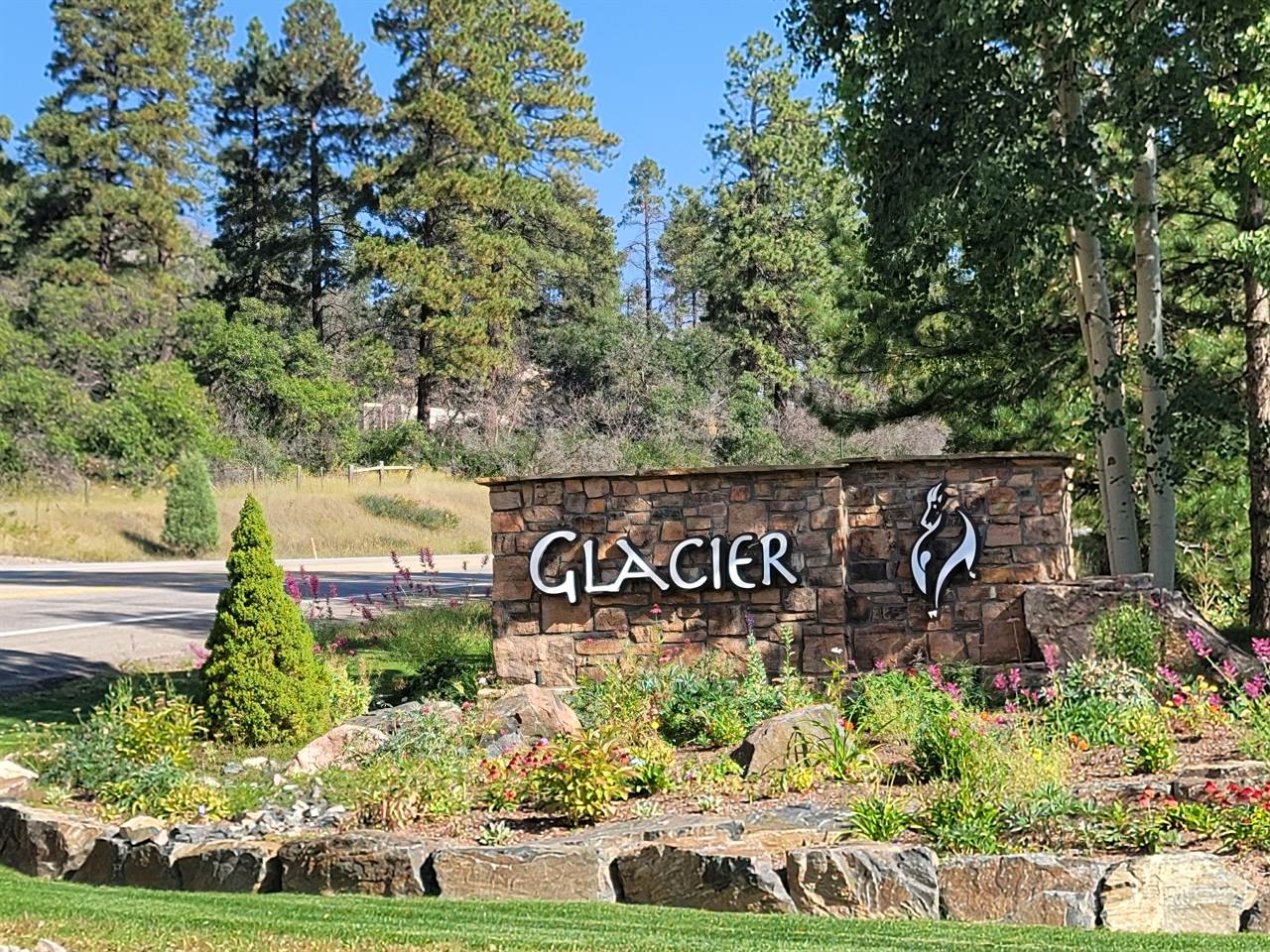 A sign for glacier in front of a tree.