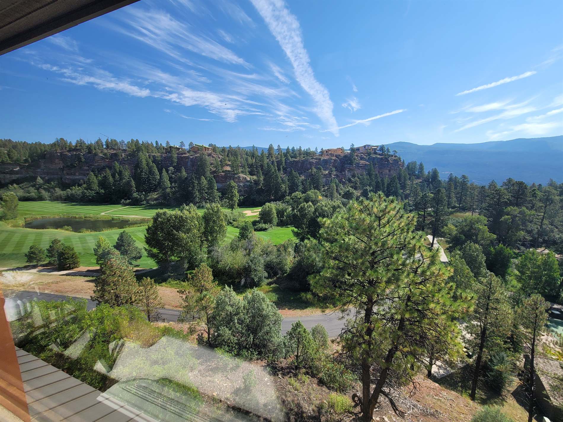 A view of a golf course from a window.