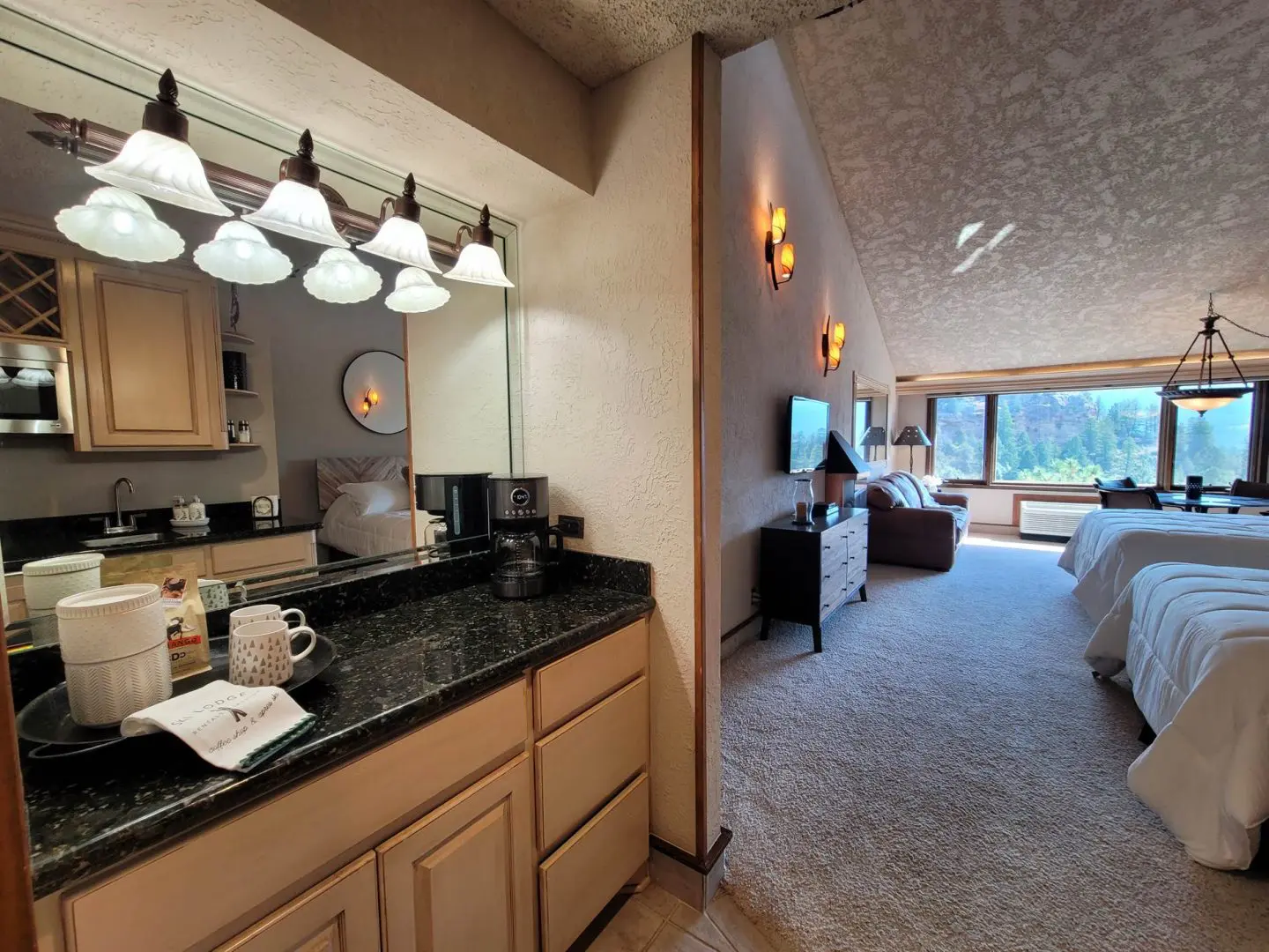 A view of a bedroom with a bed and a bathroom.