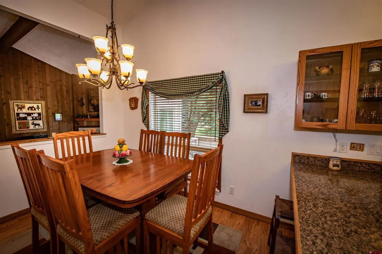 A dining room with a wooden table and chairs.