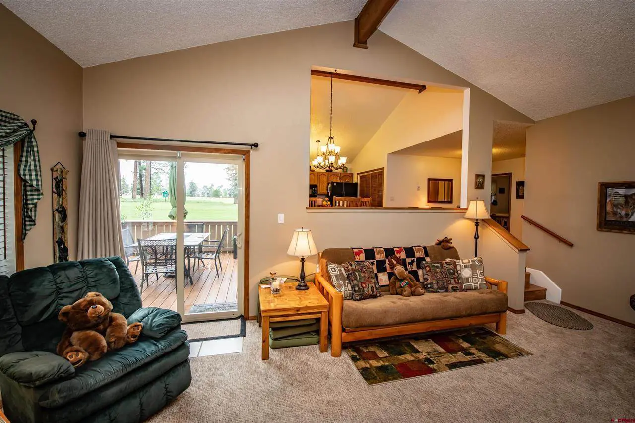 A living room with a couch and teddy bear.