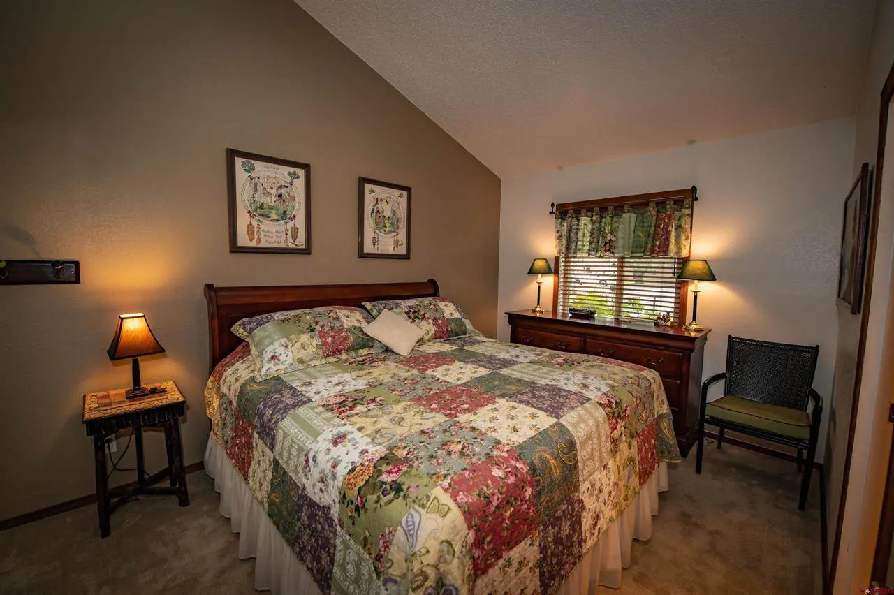 A bed in a bedroom with a floral comforter.