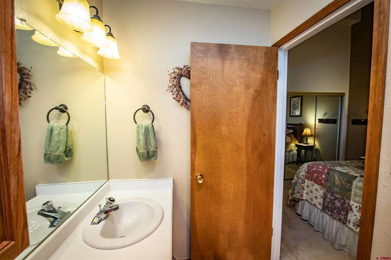 A bathroom with a wooden door and a sink.