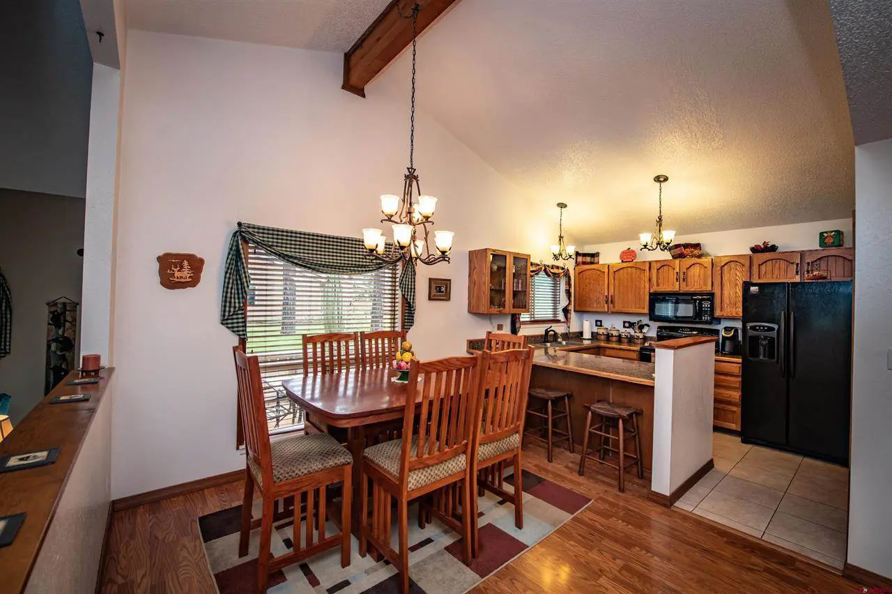 A kitchen with hardwood floors and a dining table.