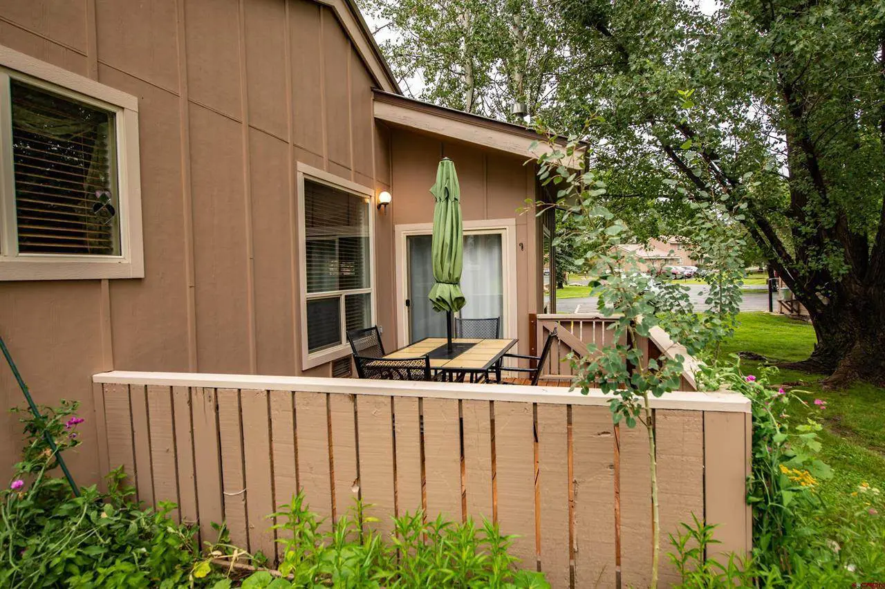 A balcony with a table and chairs.