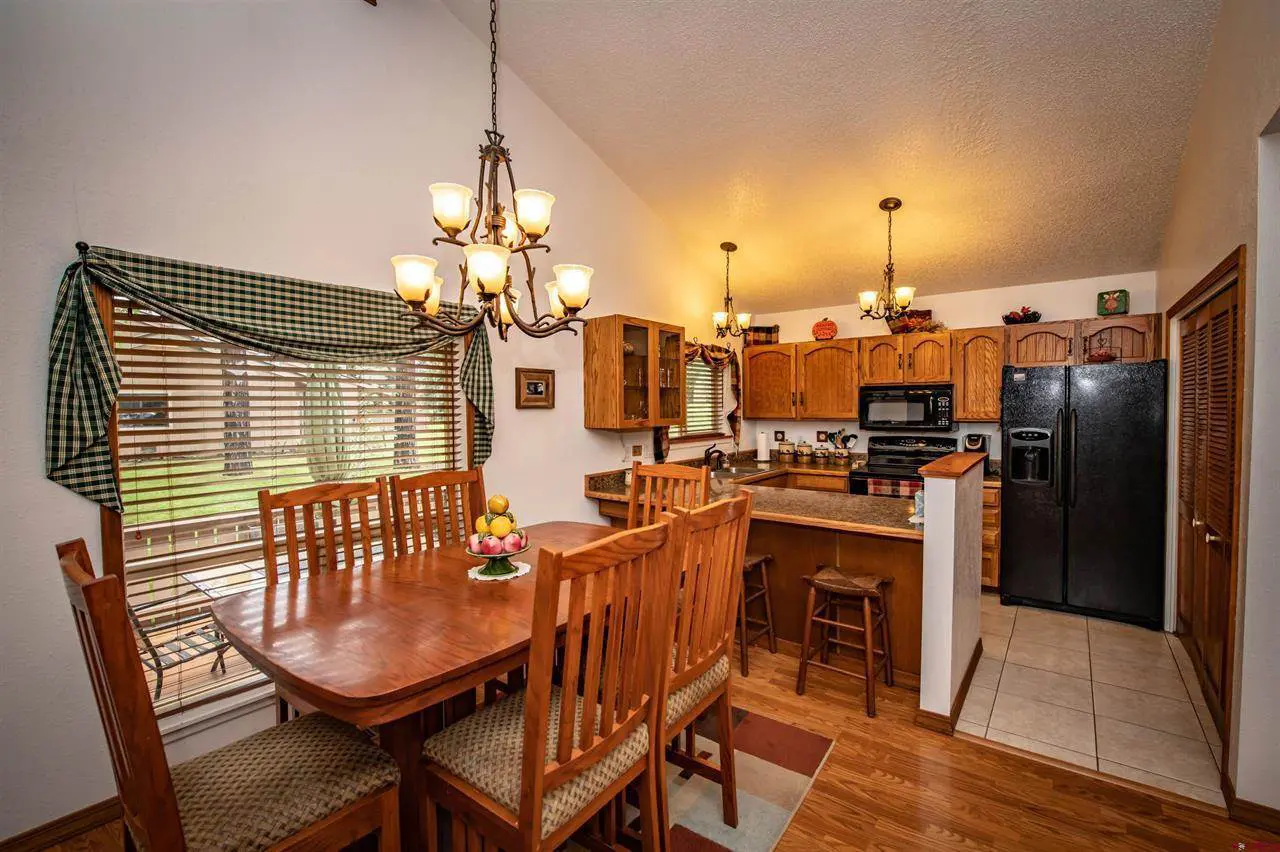 A kitchen with a dining table and chairs.