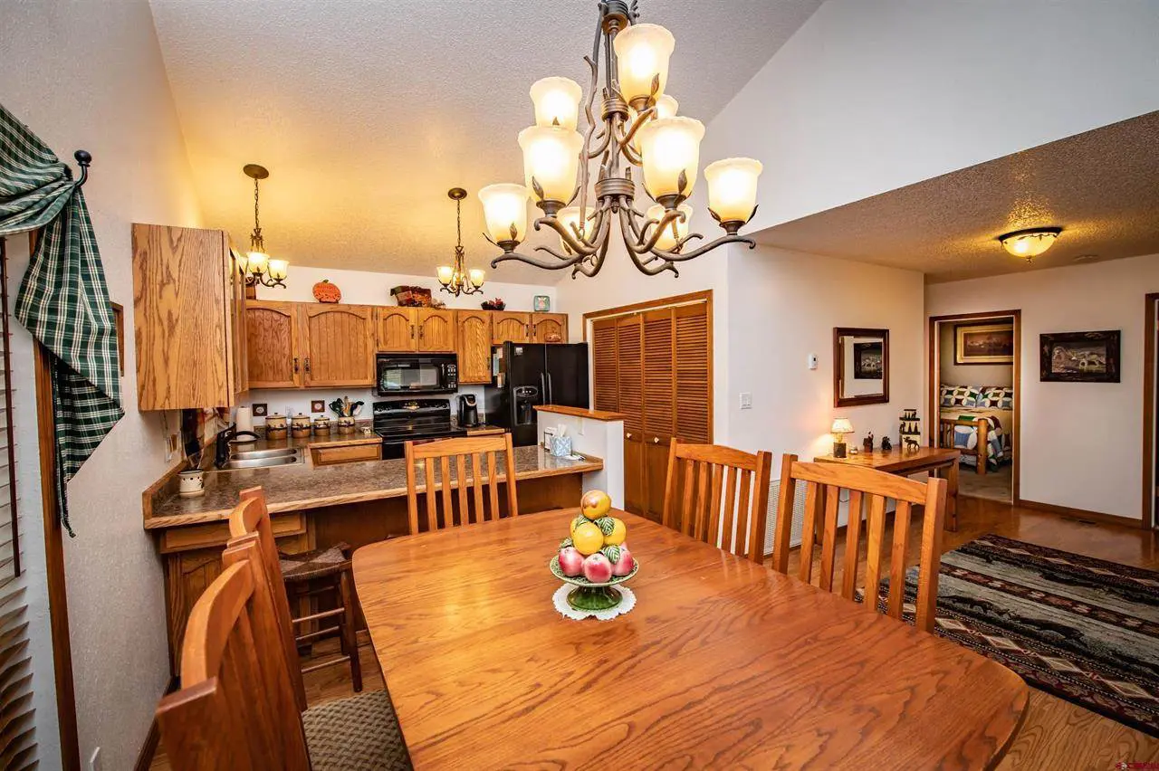 A kitchen with a dining table and chairs.