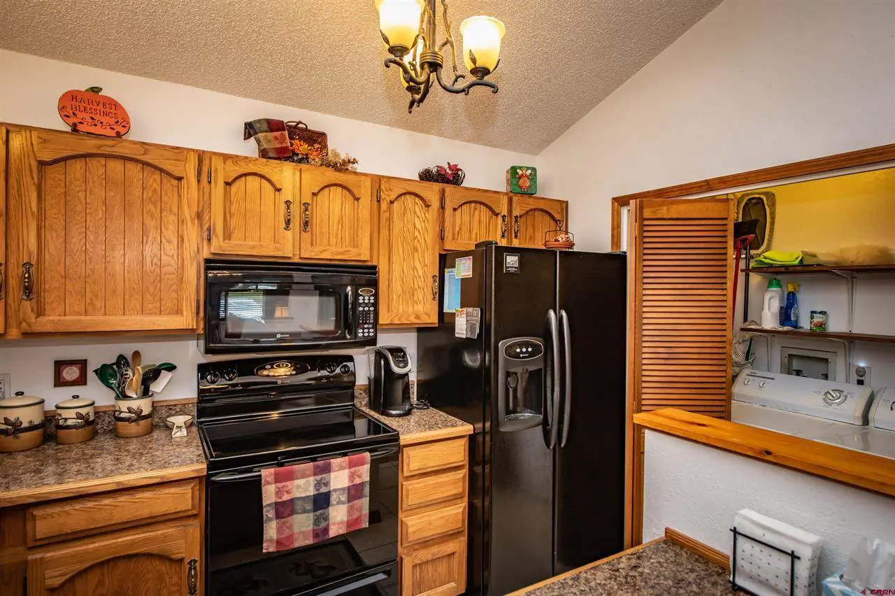 A kitchen with black appliances and wooden cabinets.