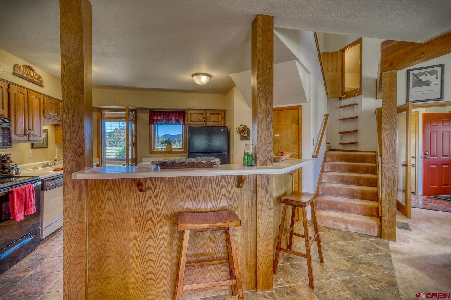 Stairs going upward with a table in the kitchen