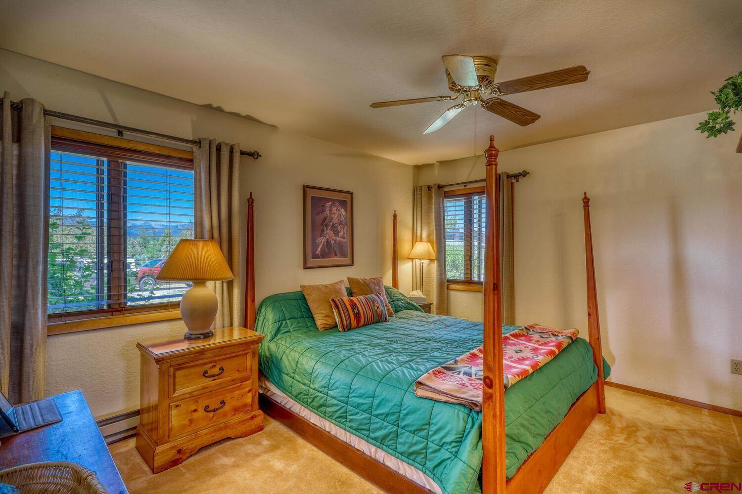 Beautiful bed inside a room with a fan on the top