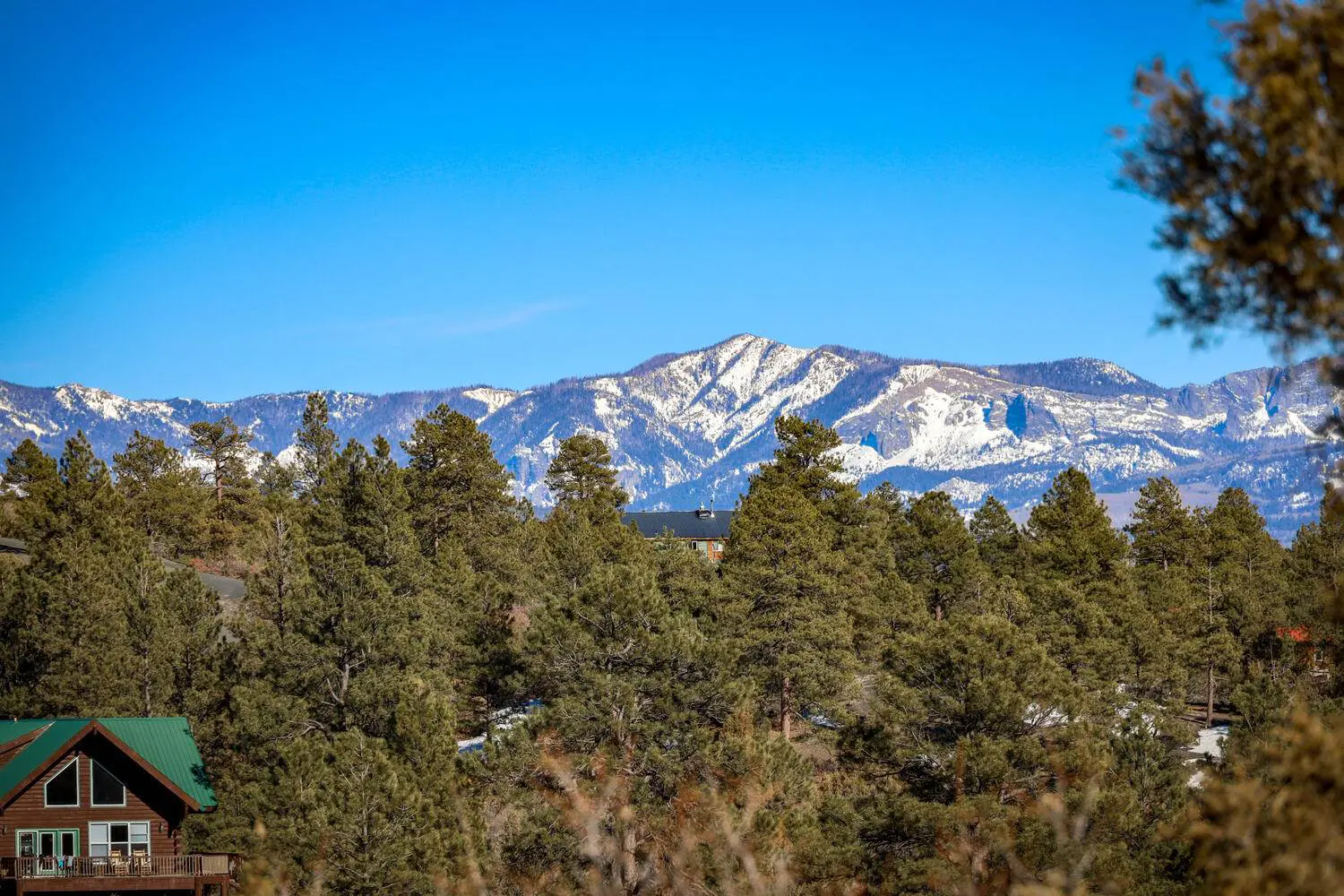 A view of the mountains from a cabin in the woods.