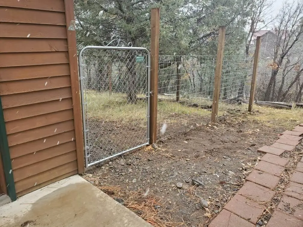 A chain link fence in front of a house.