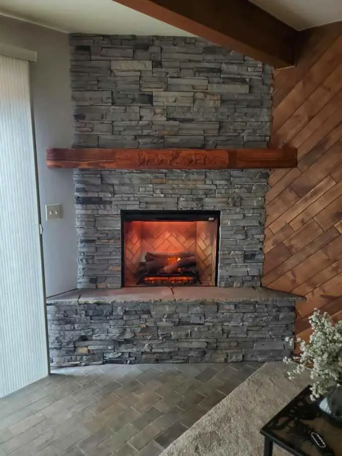 A fireplace in a living room with a stone mantel.