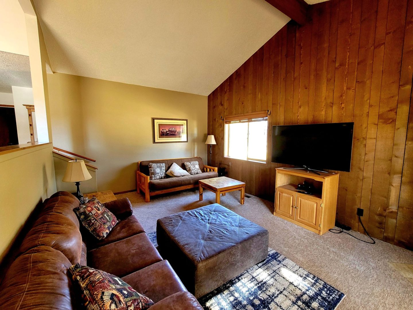 A living room with wood paneling and a tv.