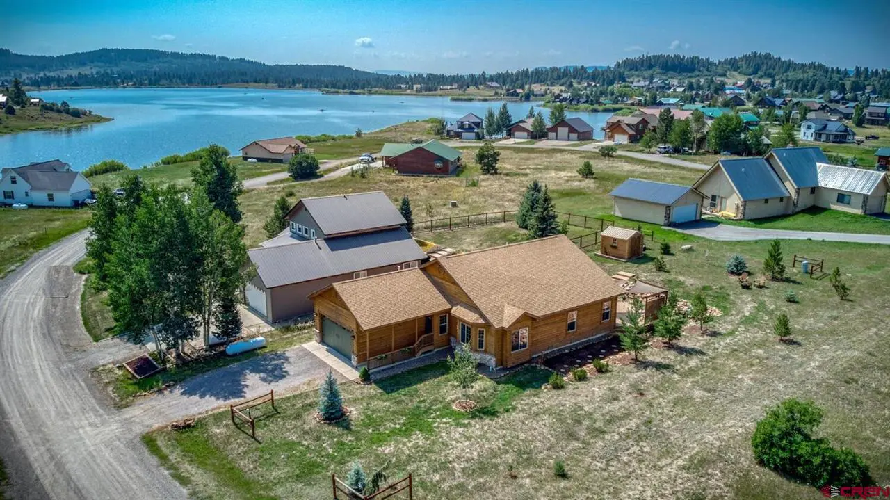 An aerial view of a house near a lake.