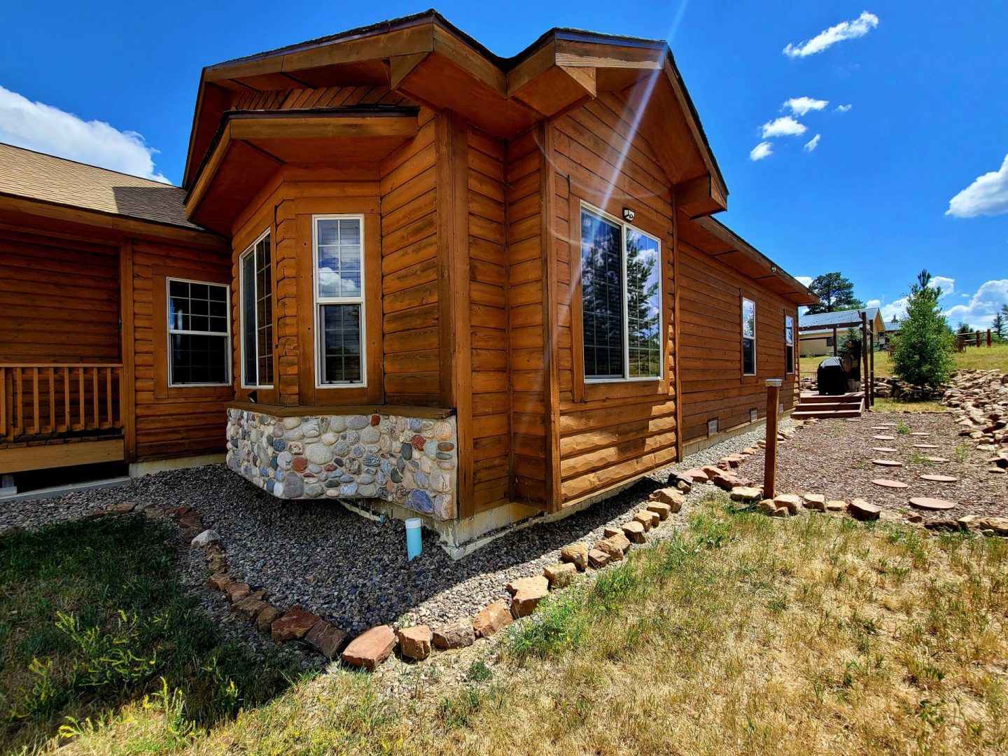 A log home in the middle of a grassy field.