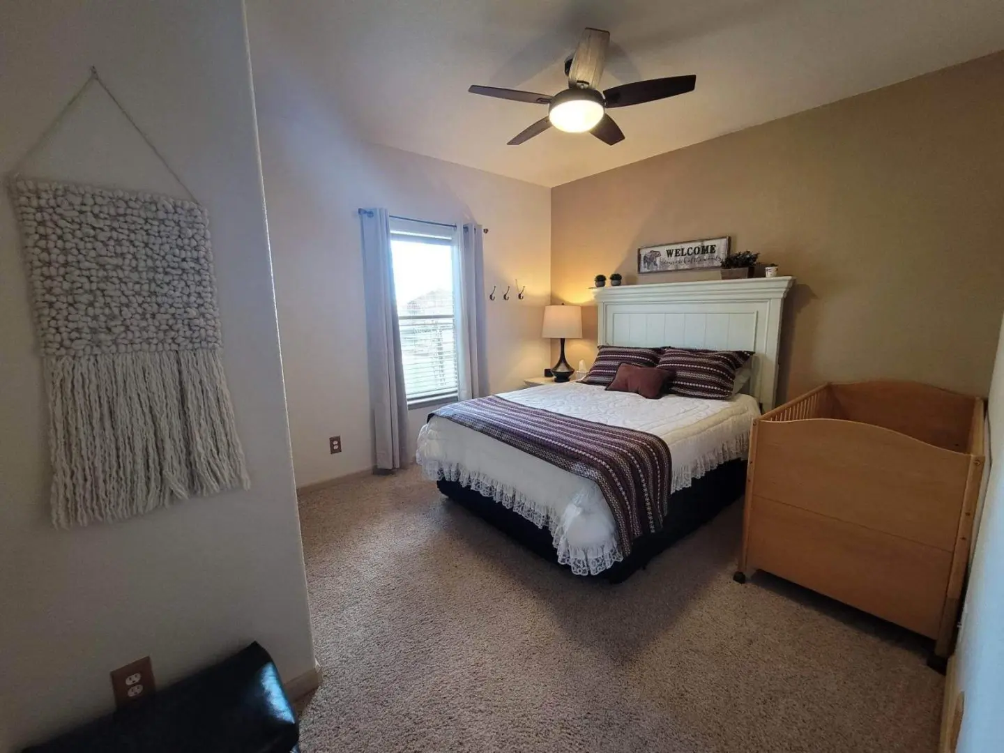 A bedroom with a bed and a ceiling fan.