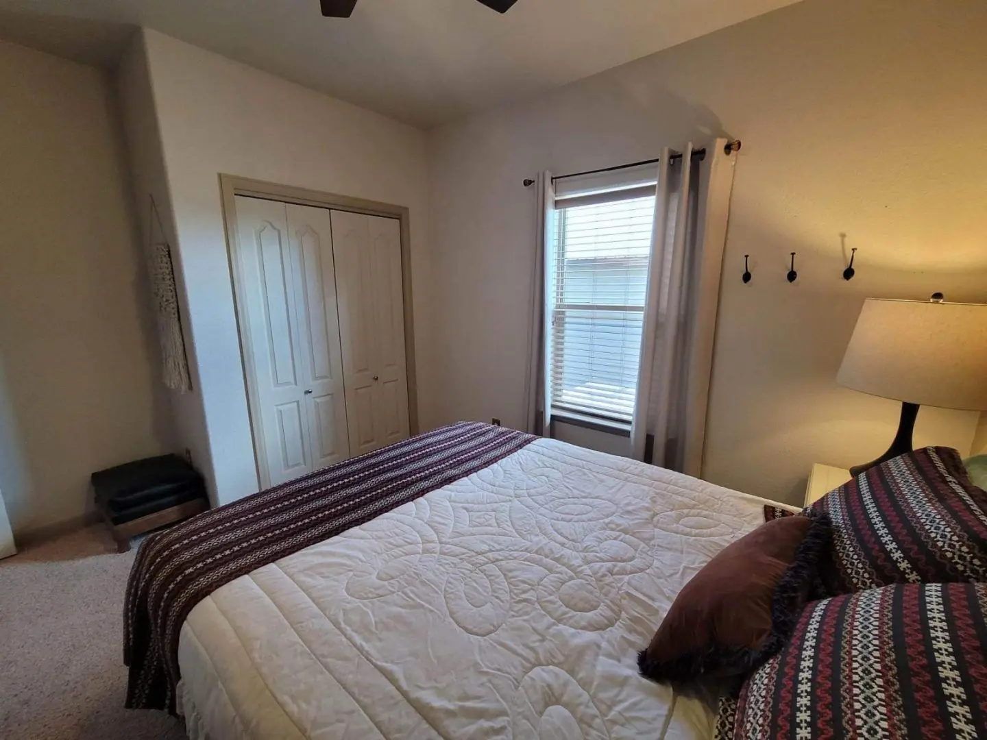 A bedroom with a bed and a ceiling fan.