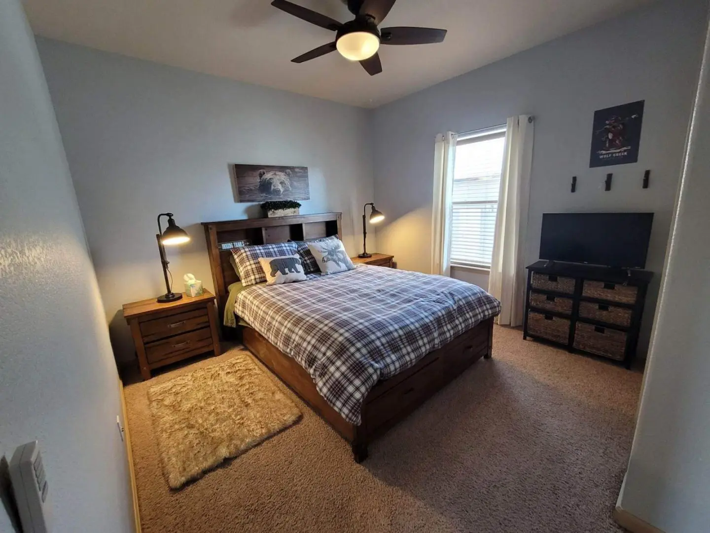 A bedroom with a bed and a ceiling fan.