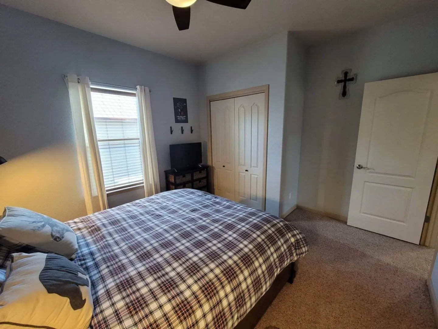 A bedroom with a bed and a ceiling fan.