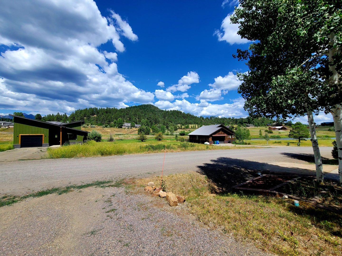 A road in the middle of a field with mountains in the background.