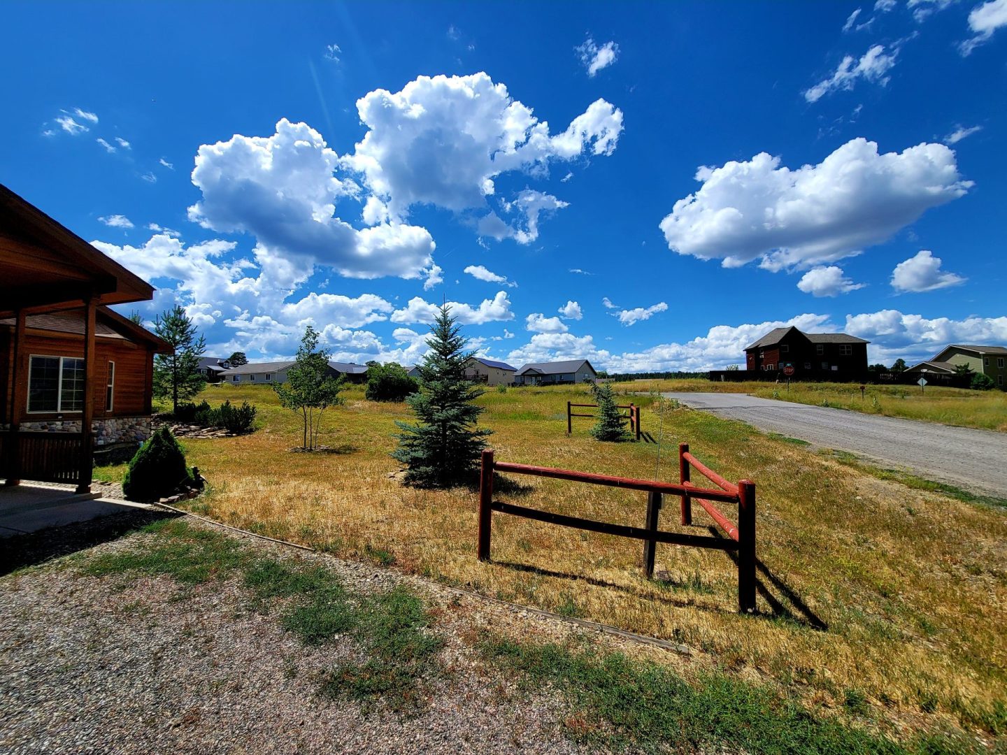 A view of a grassy field with a house in the background.