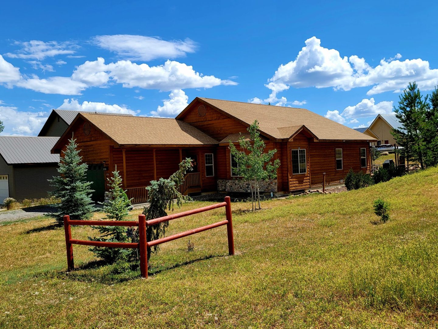 A log cabin in the middle of a grassy field.