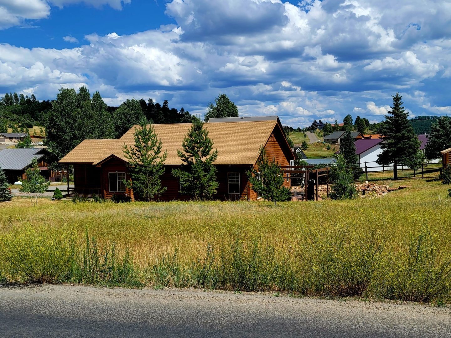 A house in the middle of a grassy field.