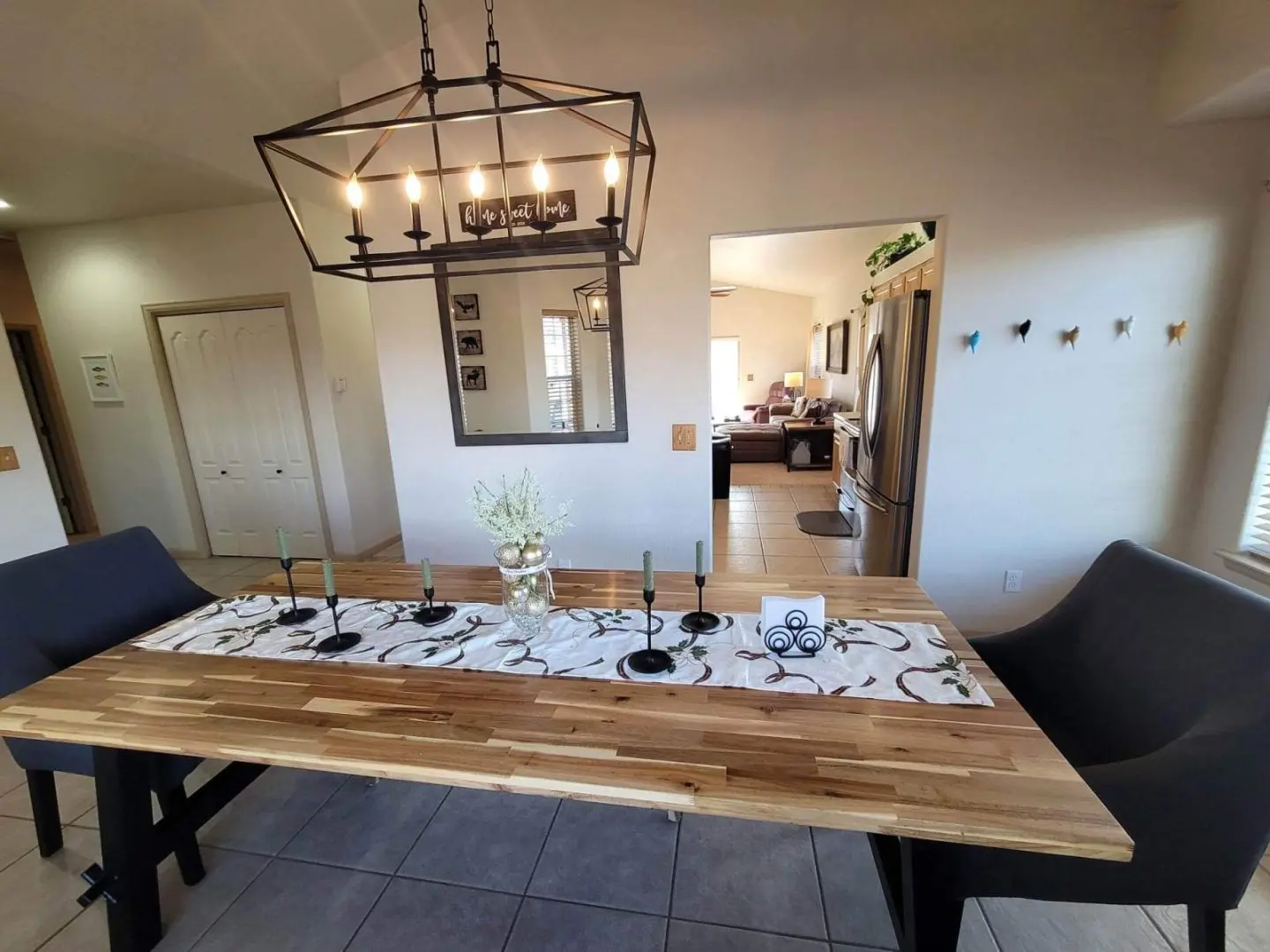 A dining room table with chairs and a chandelier.