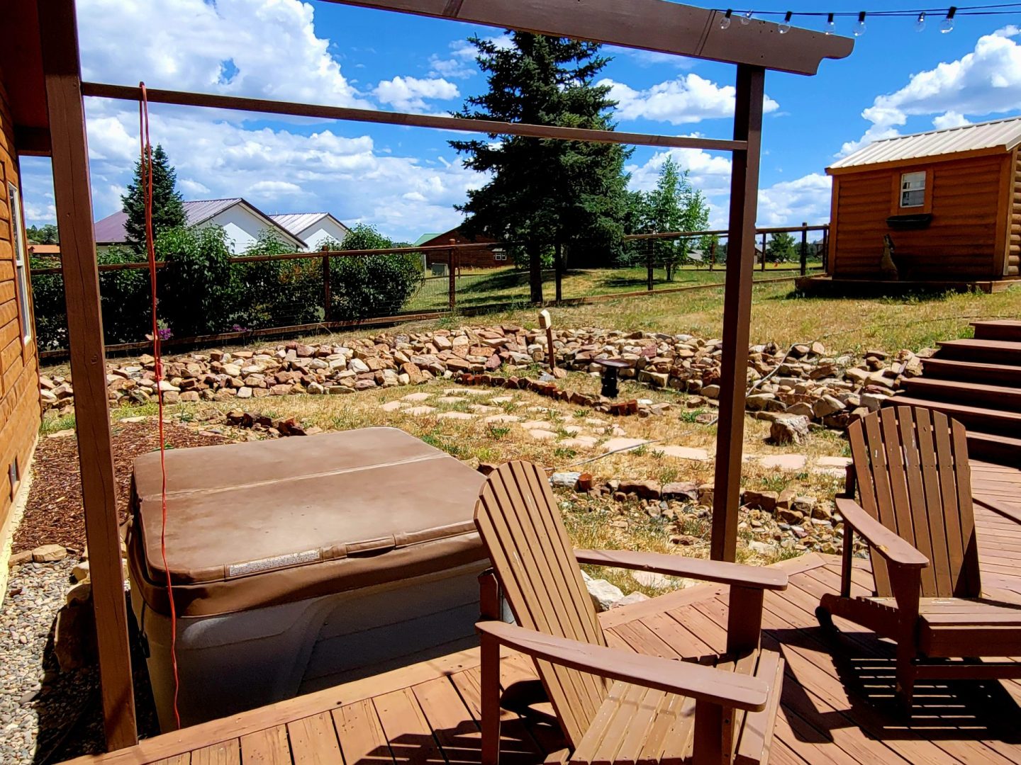 A wooden deck with chairs and a hot tub.