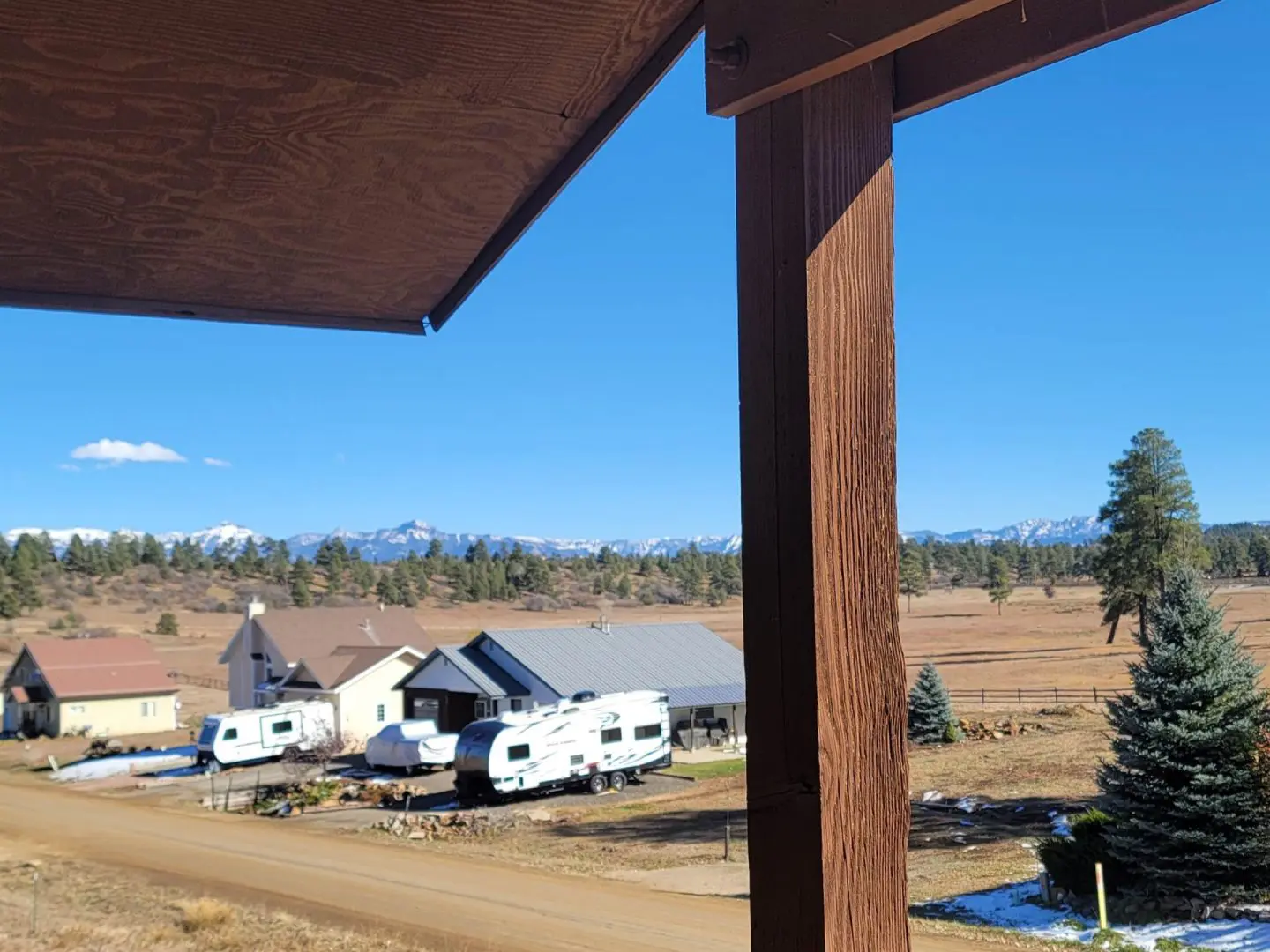 A view of a rural area with rv's parked in a field.