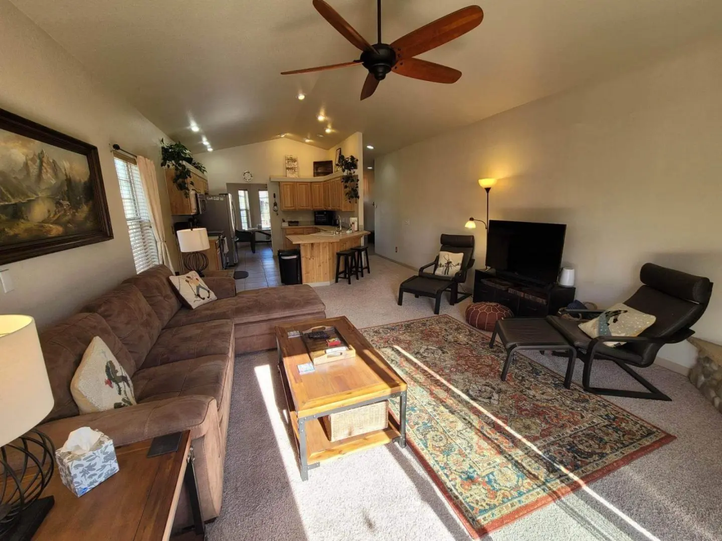 A living room with a ceiling fan and couches.