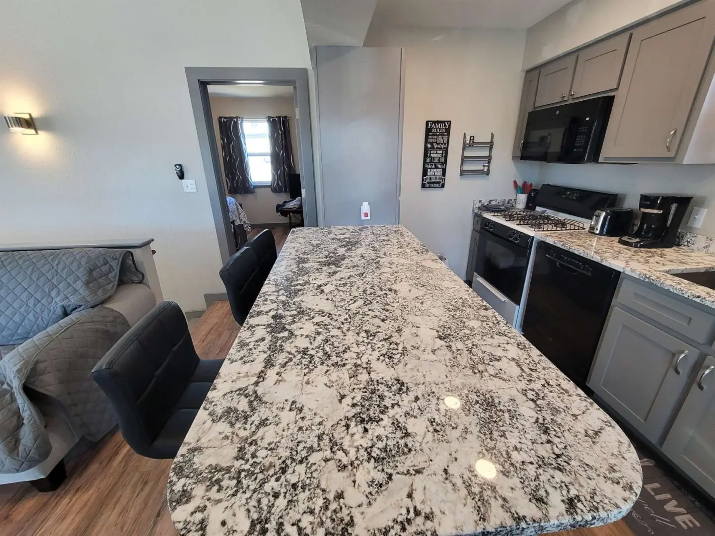 A kitchen with granite counter tops and stainless steel appliances.