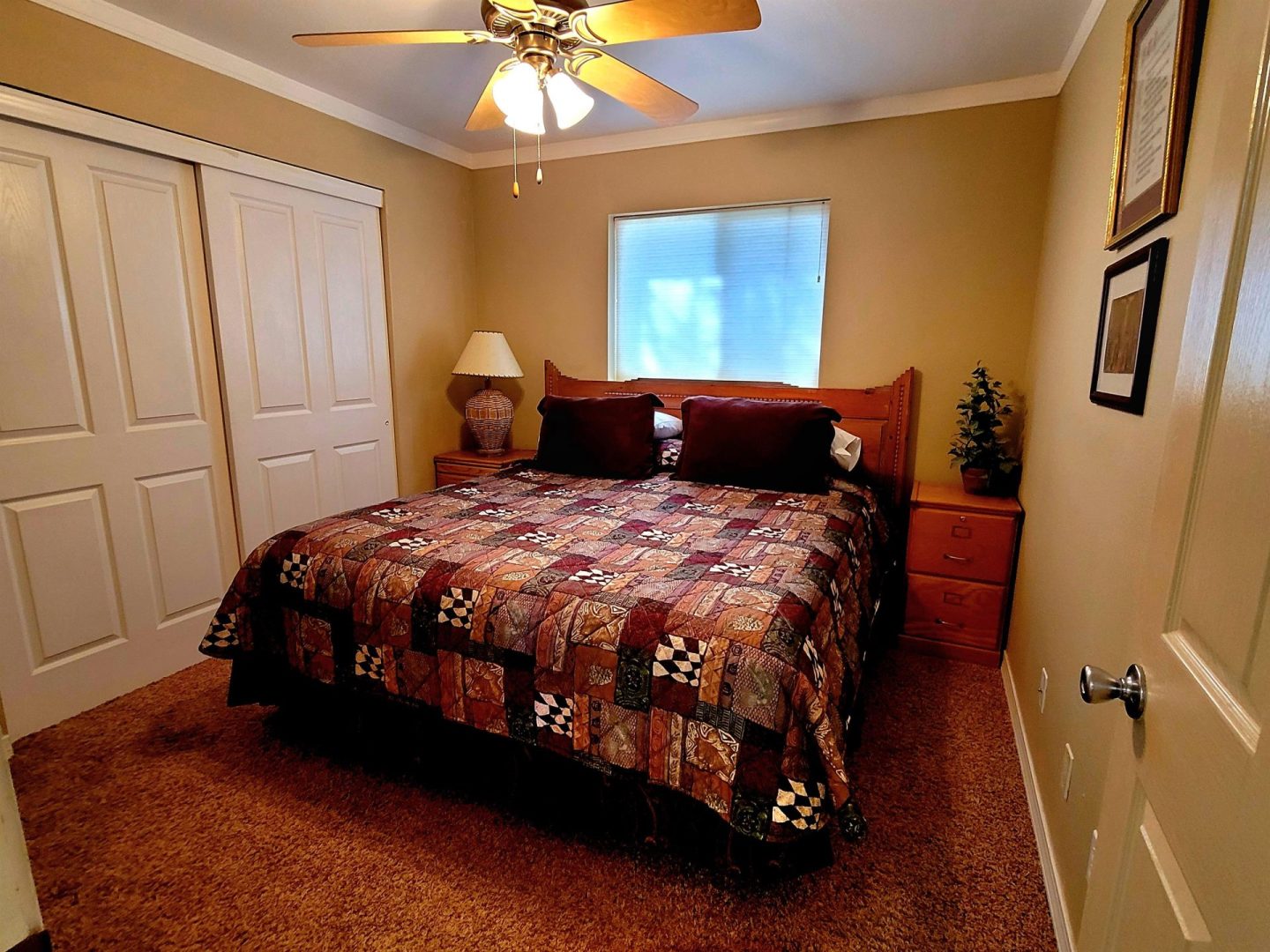 A bed in a bedroom with a ceiling fan.