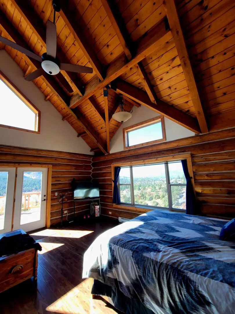 A bed in a bedroom with wooden roof.