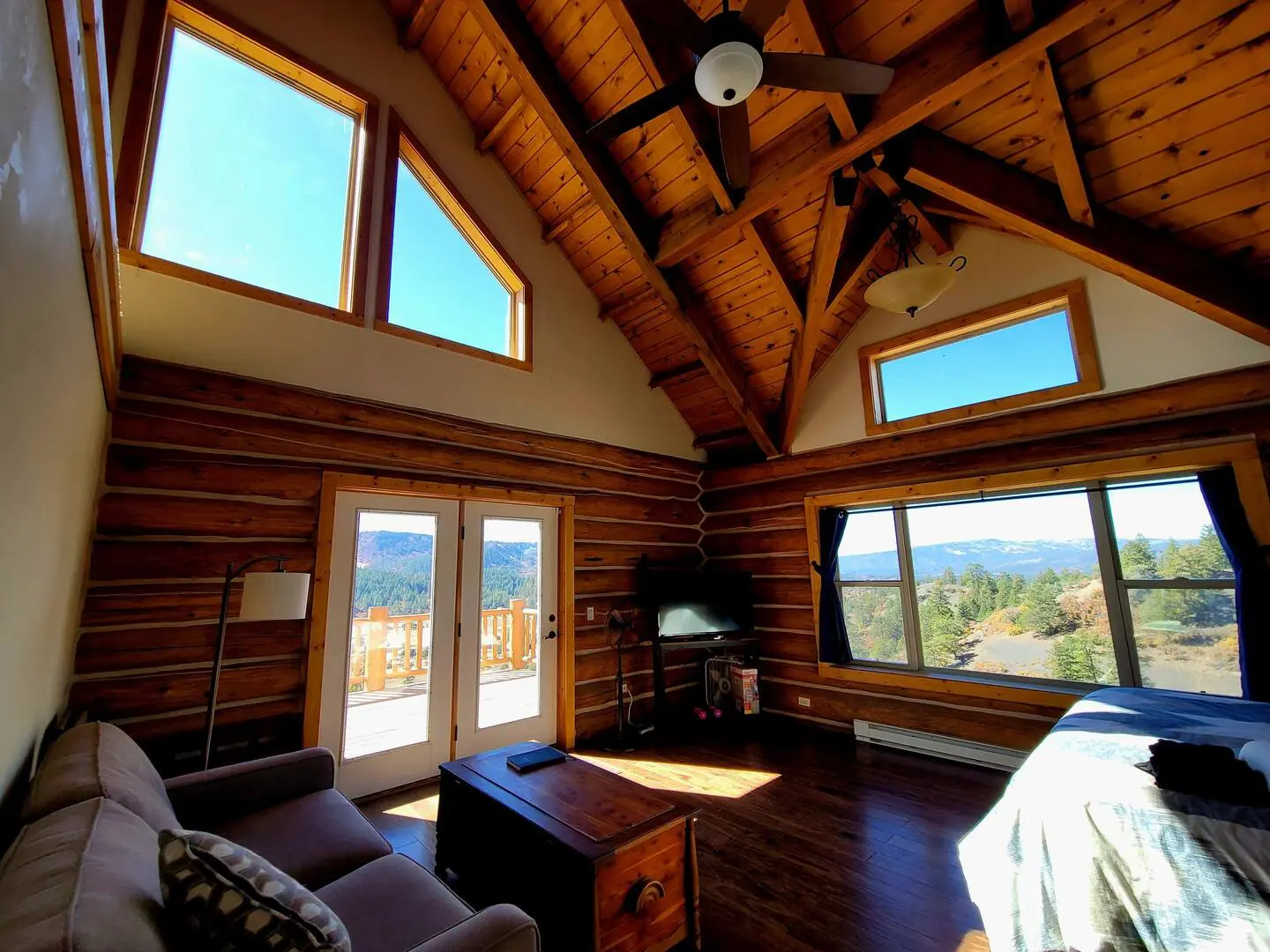 A bedroom in a log cabin with a view of the mountains.