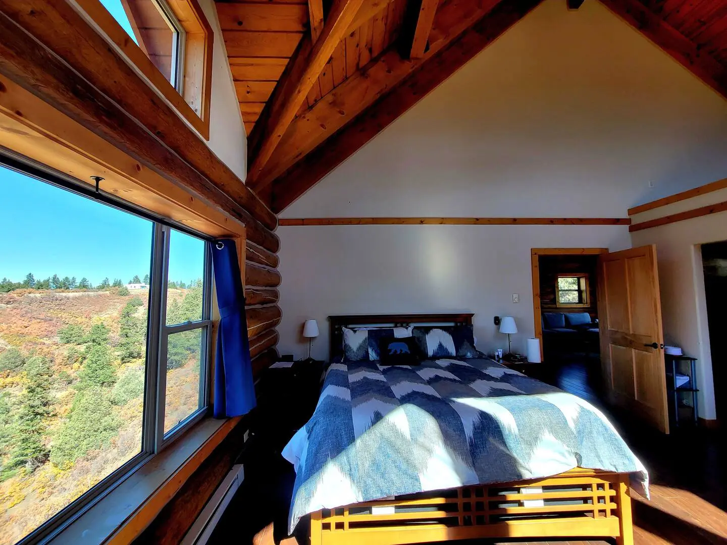 A bedroom in a log cabin with a bed and a window.