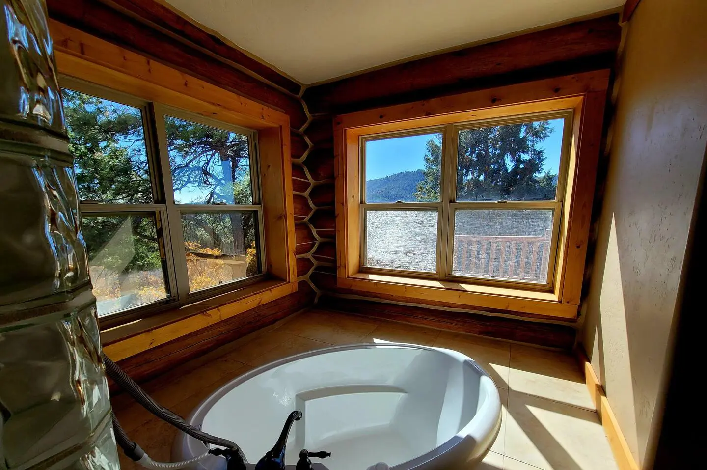 A bathroom with a tub and a view of the mountains.