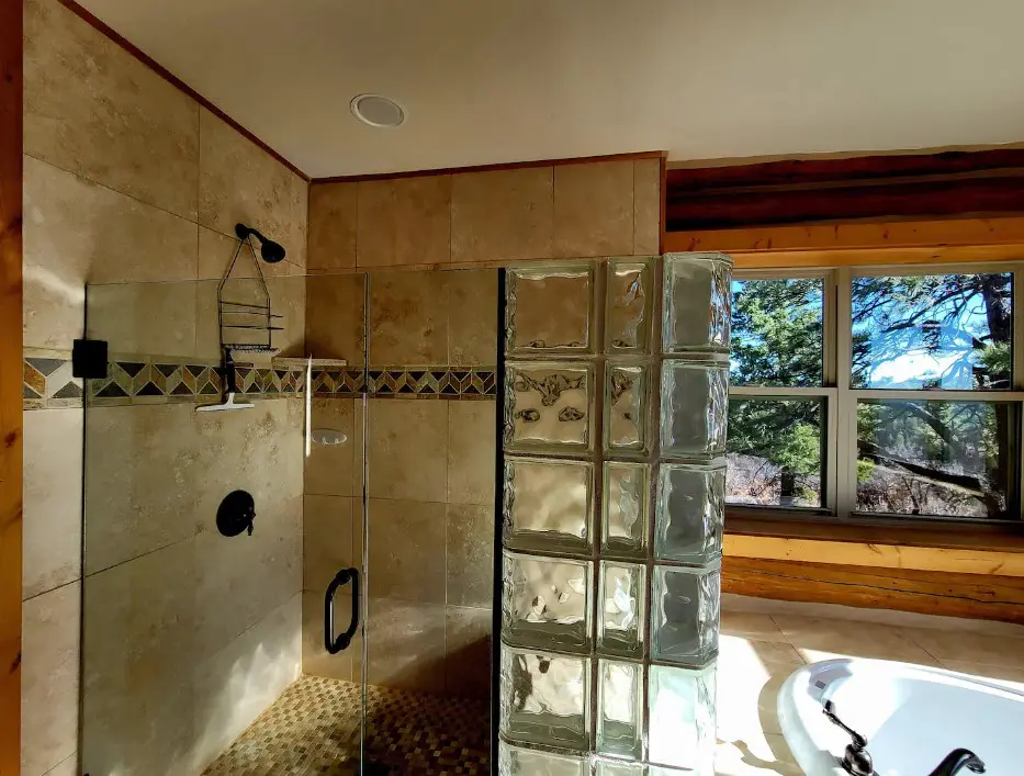 A bathroom with a glass shower stall.