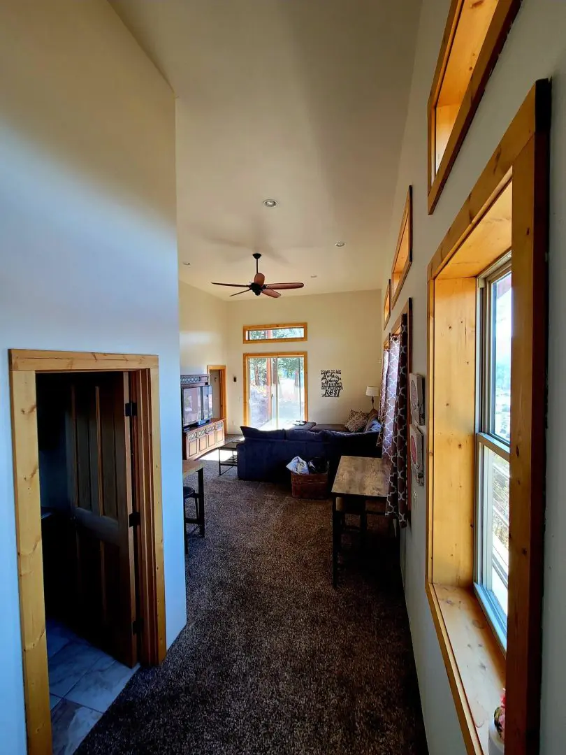 A view of a living room with a ceiling fan.